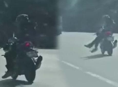 Trafikte tehlikeli anlar! Yan oturup ayaklarını sarkıttı, motosikleti bıraktı